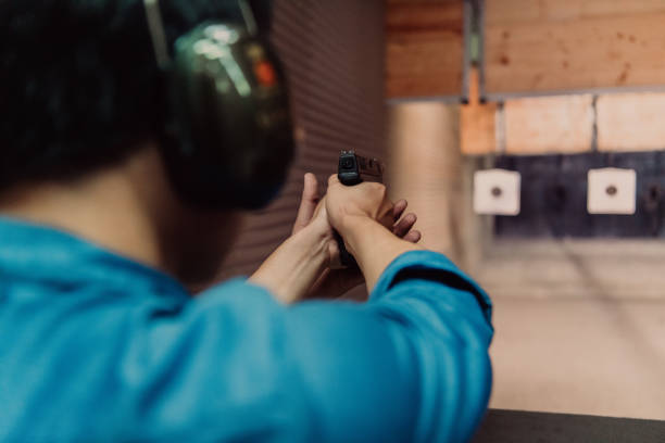 istock A man practices shooting a pistol in a shooting range while wearing protective headphones 1560234359