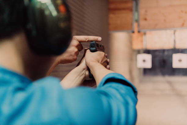 istock The trainer explaining to the man how to use the gun. Training in the shooting range 1560235463