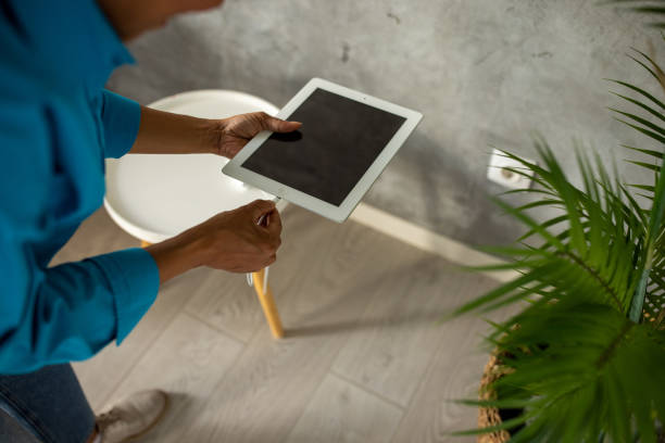 A group of digital devices - smartphones, digital tablets, e-readers - charging at home.