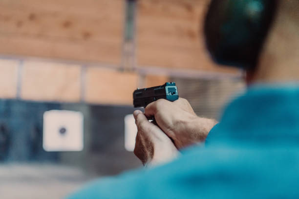 istock A man practices shooting a pistol in a shooting range while wearing protective headphones 1560243518