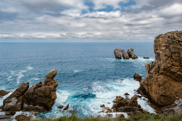 istock Spectacular coastal landscape with steep cliffs and rock formations carved out by the wave action of the Cantabrian Sea 1560245089