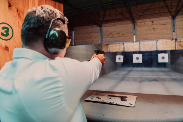 istock A man practices shooting a pistol in a shooting range while wearing protective headphones 1560247133