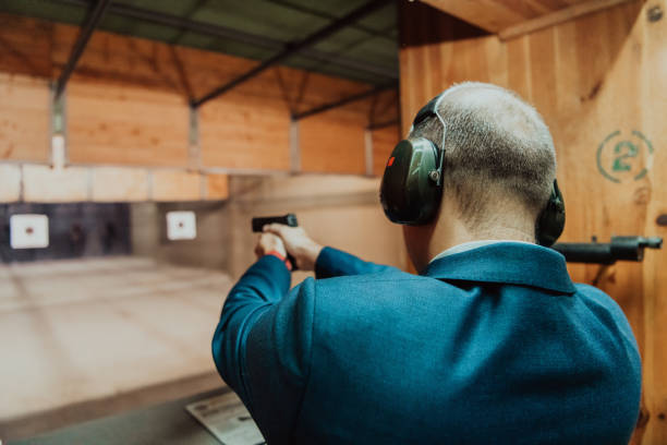 istock A man practices shooting a pistol in a shooting range while wearing protective headphones 1560248326
