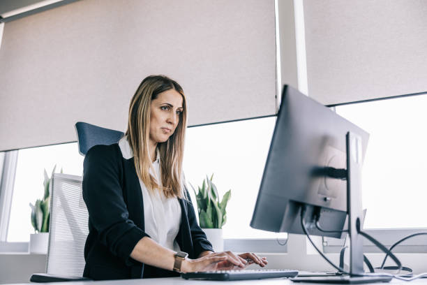 istock Focused businesswoman working at the office behind computer 1560251536