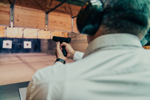 istock A man practices shooting a pistol in a shooting range while wearing protective headphones 1560253230