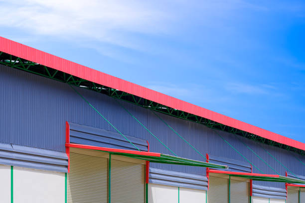 istock Automatic roller shutter doors with awning of modern rental warehouse building against blue sky background 1560263312