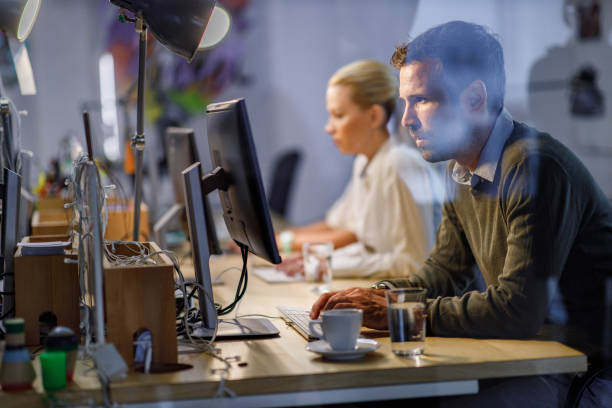 istock Profile view of a male programmer reading codes on a PC in the office. 1560264974