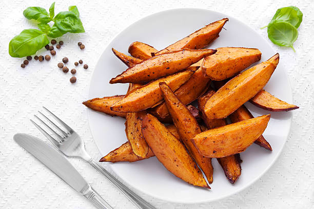 Sweet potato wedges Delicious homemade sweet potato wedges on a plate. Baked Sweet Potato Fries stock pictures, royalty-free photos & images