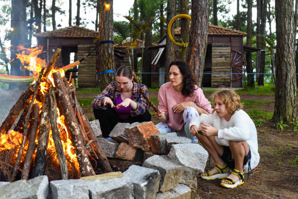 istock Mother with her daughters spending time together, kindle a fire and throw sticks 1560271444