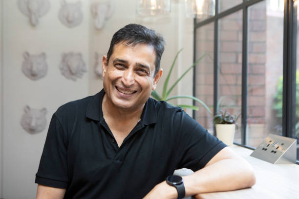istock Smiling mature man standing by a window 1560274784