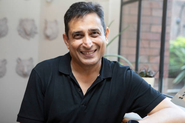 istock Smiling mature man standing by a window 1560275343