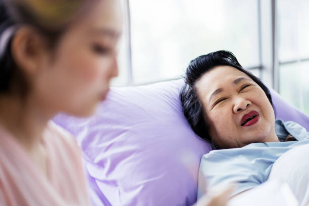 istock Caring nurse talks with senior female patient 1560278571