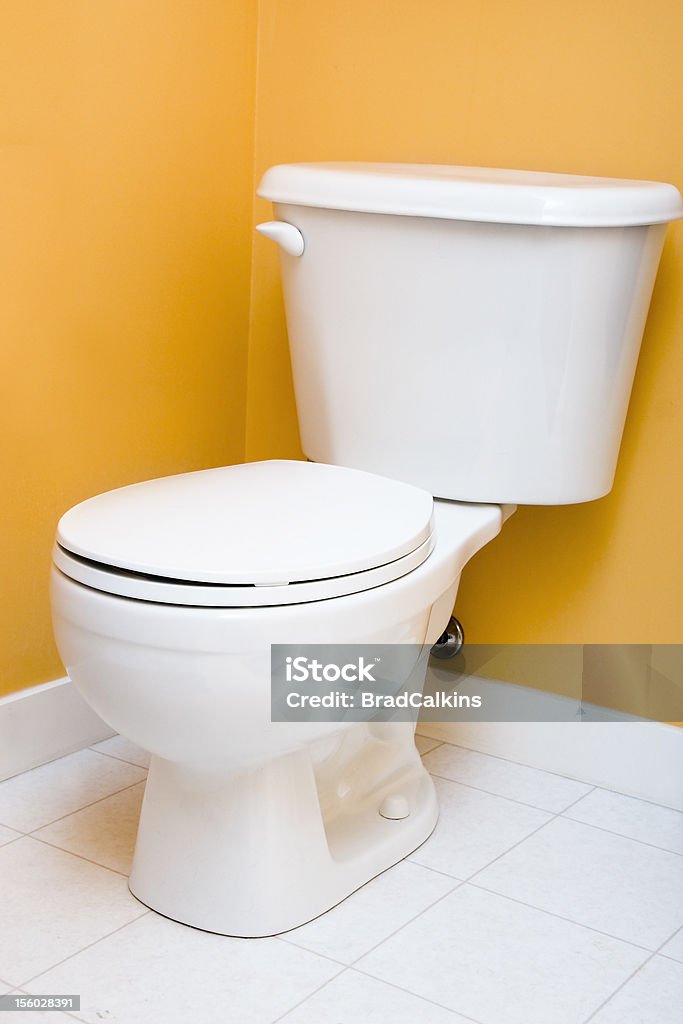 Low flow toilet Low flow toilet in yellow bathroom Efficiency Stock Photo