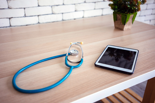 Medical stethoscope with digital tablet on table