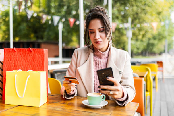 istock Young Woman's Coffee, Shopping, and Credit Card Delight 1560334184