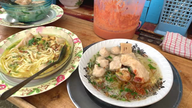 Bowls of meatballs noodle soup on a cart. Indonesian street food.