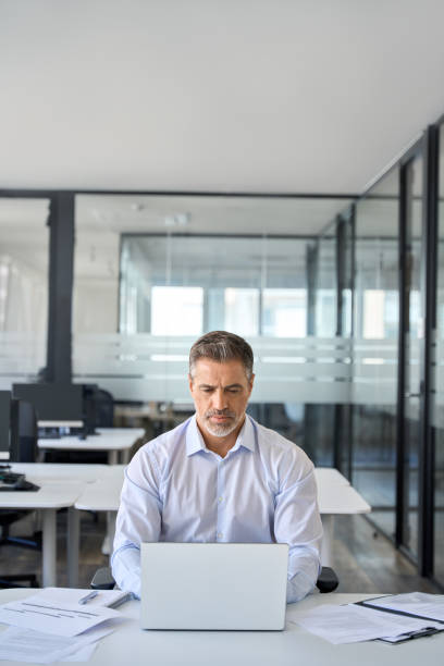 istock Mature adult business man manager using laptop computer in office. 1560353164