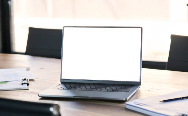 istock Laptop mock up on office board room table, white mockup computer screen. 1560358053