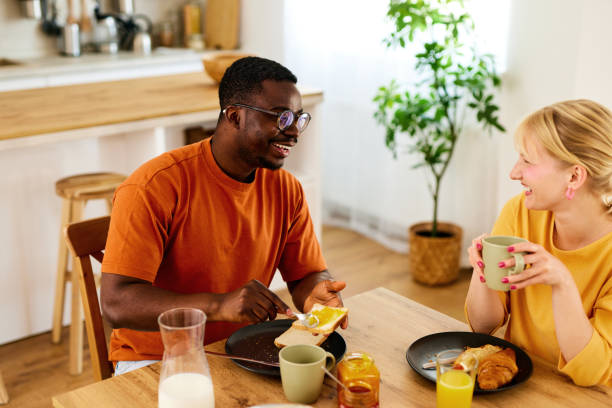 istock Multiracial couple enjoying breakfast together at home 1560360278