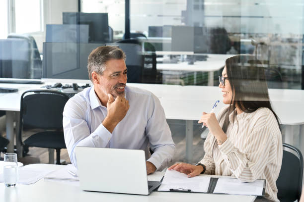istock Two happy diverse professional executives working in office with laptop. 1560361933