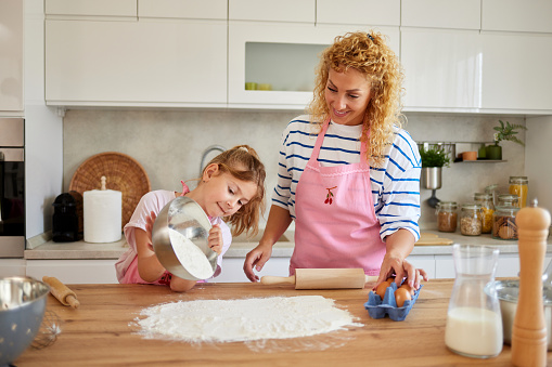 Mother and daughter making cakes together in the kitchen