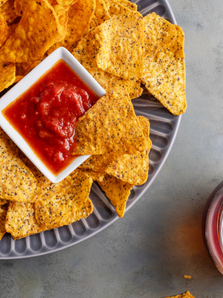 istock Nachos chips, Corn chips in bowl, Tortilla Chip, Potato Chips, Chips, Corn chips nachos and dip sauce, Mexican nachos or tortilla chips in a bowl with is dipped into chili salsa sauce 1560395196