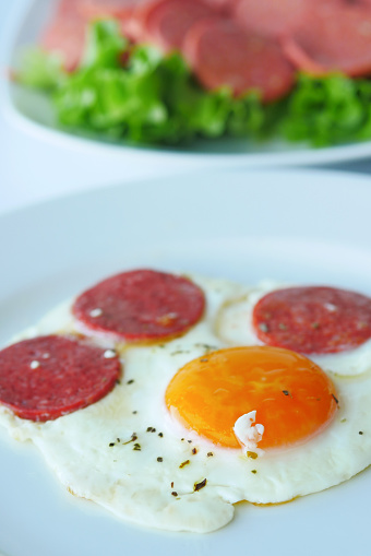 fried egg mixed with sausage on a plate .
