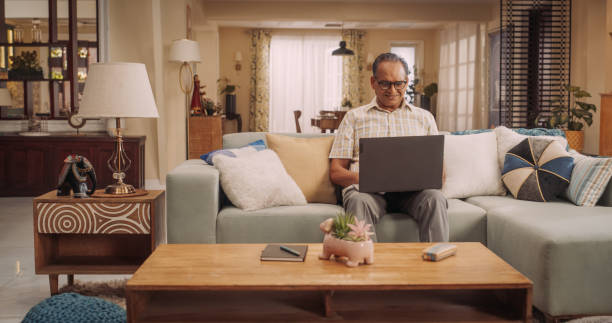 istock Elderly Indian Man Using Laptop at Home: Using Online Forums to Explore Interests, Delving into History, Arts, and Literature. Cultivating Wisdom and Sharing Stories on Social Media. Medium Static 1560456067