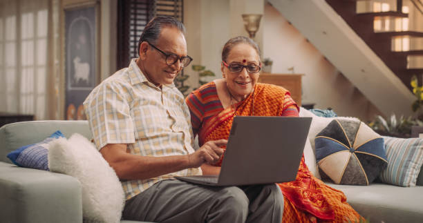 istock Elderly Couple Using Laptop at Home: Exploring New Interests, Discovering Online Communities, and Enriching Their Lives Through Technology. Embracing the Digital Age with Passion. Medium Shot. 1560457135
