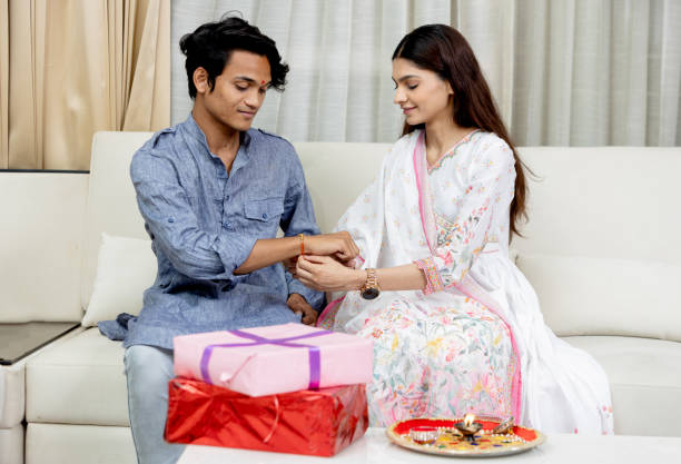 sister tying rakhi on her brother's wrist on the occasion of raksha bandhan - british indian ocean territory imagens e fotografias de stock