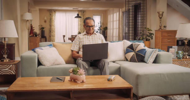 istock Elderly Indian Man Using Laptop at Home: Using Online Forums to Explore Interests, Delving into History, Arts, and Literature. Cultivating Wisdom and Sharing Stories on Social Media. Medium Static 1560475235
