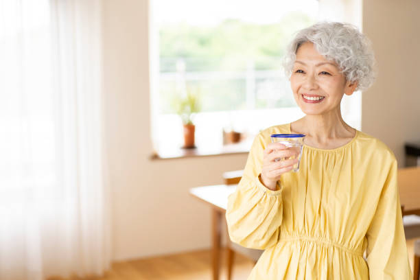 A senior woman is drinking water.
