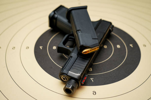 istock A pistol with a  loaded magazine lying on a paper target 1560508439