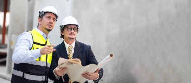 Caucasian construction architect Engineering man and busines owner in safety hardhat working on blue print at precast factory industrial. Heavy Industry Manufacturing Factory. Prefabricated concrete walls arquitecto de construcción caucásico ingeniero y propietario de negocios en casco duro de seguridad trabajando en el plano en fábrica de prefabricados industriales. fábrica de fabricación de la industria pesada. muros prefabricados de hormigón