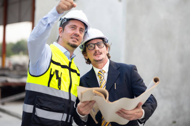 Caucasian construction architect Engineering man and busines owner in safety hardhat working on blue print at precast factory industrial. Heavy Industry Manufacturing Factory. Prefabricated concrete walls arquitecto de construcción caucásico ingeniero y propietario de negocios en casco duro de seguridad trabajando en el plano en fábrica de prefabricados industriales. fábrica de fabricación de la industria pesada. muros prefabricados de hormigón