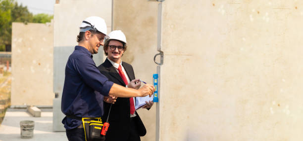 Caucasian construction architect Engineering man and busines owner in safety hardhat working on blue print at precast factory industrial. Heavy Industry Manufacturing Factory. Prefabricated concrete walls arquitecto de construcción caucásico ingeniero y propietario de negocios en casco duro de seguridad trabajando en el plano en fábrica de prefabricados industriales. fábrica de fabricación de la industria pesada. muros prefabricados de hormigón