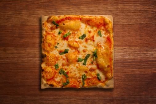 Square shaped pizza on a wood background