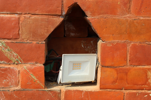 Foot light or spot light kept inside niche of a brick wall to give a classic look , foot light for gardens.