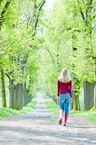 istock woman in spring alley 156052438