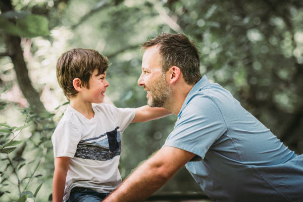 istock father with his little boy playing with him in nature. 1560525144