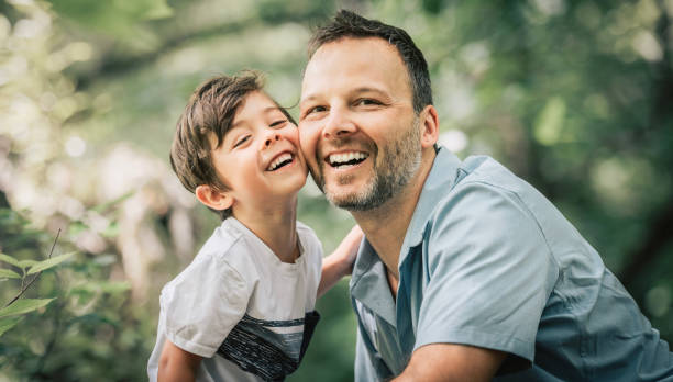 A father with his little boy playing with him in nature.