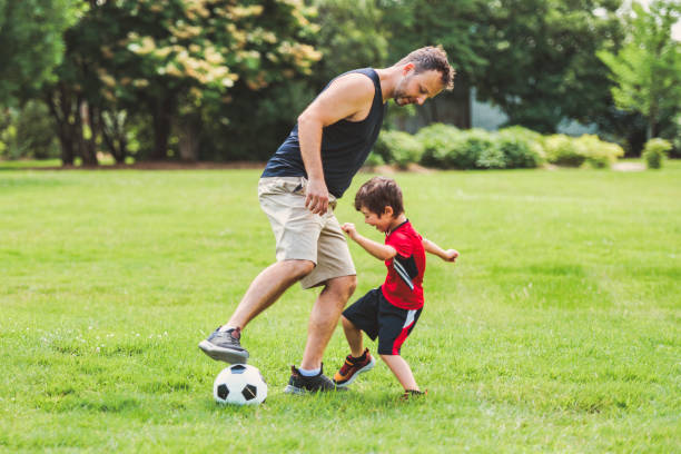 istock Young soccer player having fun on a field with his father 1560531664