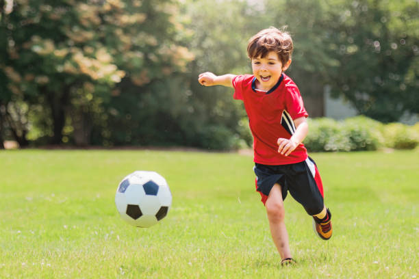 Young soccer player having fun on a field with his father
