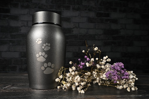 In remembrance of a pet. Pet urn beside a flower bouchet.