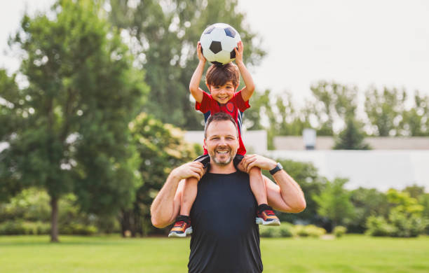istock Young soccer player having fun on a field with his father 1560531677