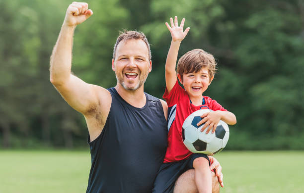 istock Young soccer player having fun on a field with his father 1560531691