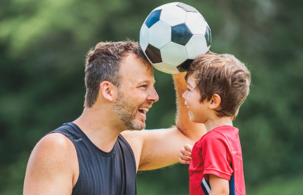istock Young soccer player having fun on a field with his father 1560531700