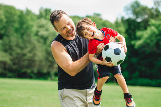 istock Young soccer player having fun on a field with his father 1560531997