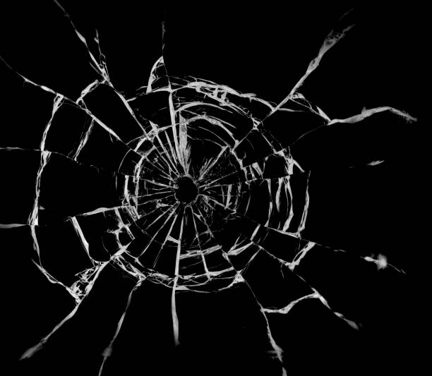 istock Texture of broken glass. Hole from a ball on a black background. 1560533031