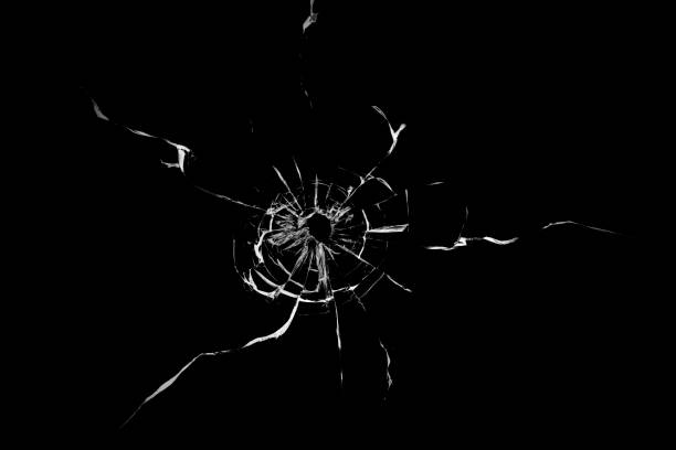 istock Texture of broken glass. Hole from a ball on a black background. 1560534540
